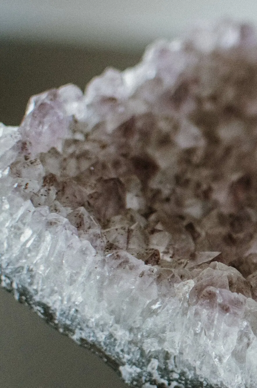 A close-up of a pale amethyst crystal cluster, its clear and lilac points catching soft light.