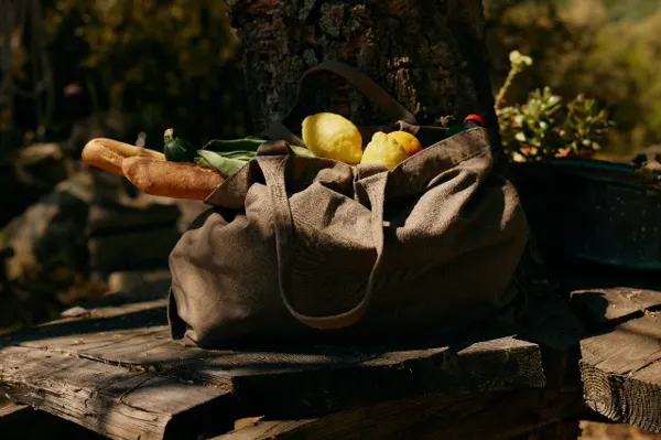 A market bag with lemons and a loaf of bread, wide frame.