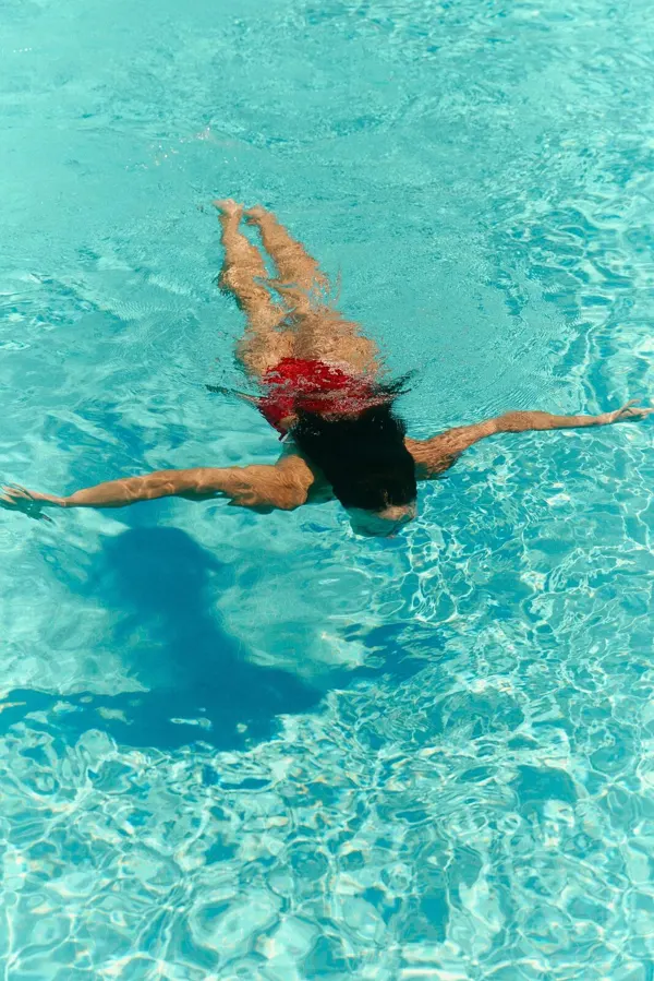 Overhead — a swimmer crossing turquoise water.