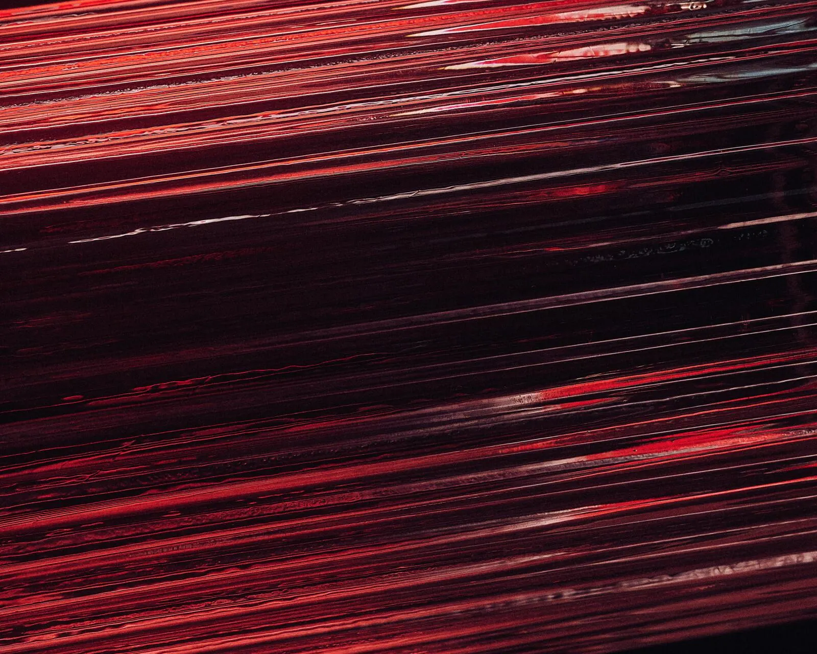 An abstract red streak of light across black — velocity.